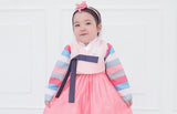 Young girl funny face and wearing a girls korean hanbok with pink top and skirt