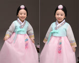 Young girl smiling and wearing a girls korean hanbok with lavender top and pink skirt
