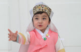 Young boy wearing a pink and gray korean hanbok
