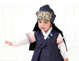 Young boy wearing a navy korean hanbok and holding out arm