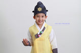 Young boy wearing a sunny yellow hanbok and blue hat and laughing