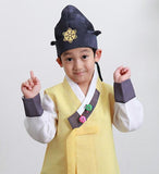 Young boy wearing a sunny yellow hanbok and blue hat