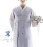 Man wearing custom grooms hanbok pastel lilac top while holding flowers