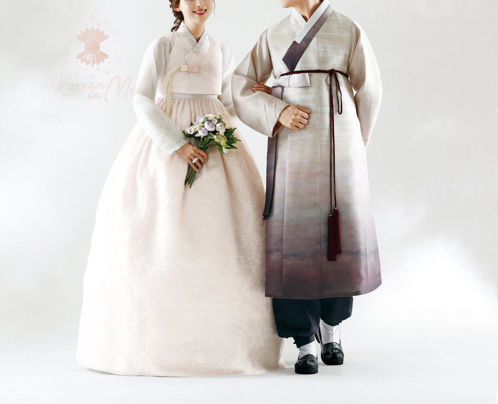 Woman wearing a custom womens bridal hanbok in lace and pastel pink style while with man