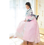 Woman sitting on a high chair and wearing a custom womens bridal hanbok with pastel and pink style