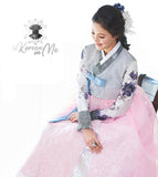 Woman sitting and wearing a custom womens bridal hanbok with pastel and pink style