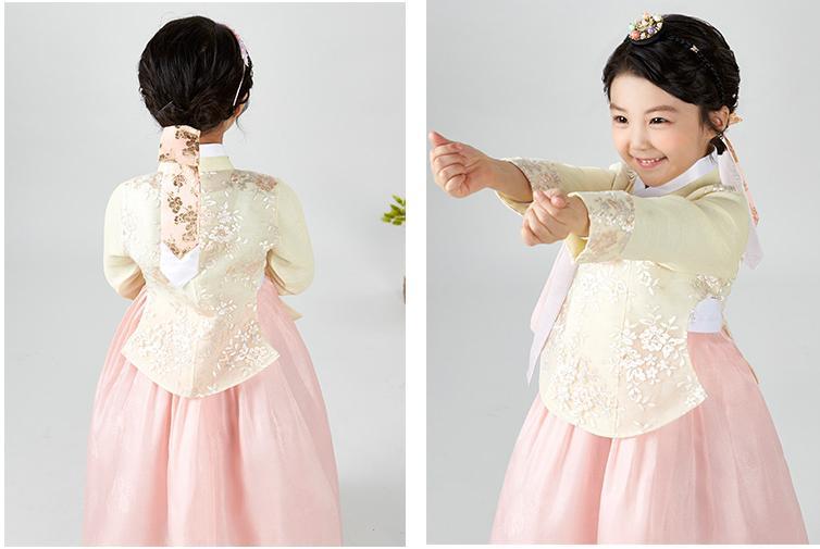 Back and side view of Young girl wearing a girls korean hanbok with pastel yellow top and pink skirt