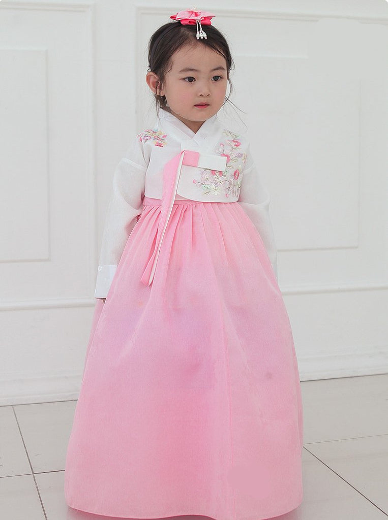 Young girl posing in a girls korean hanbok with white top and red skirt