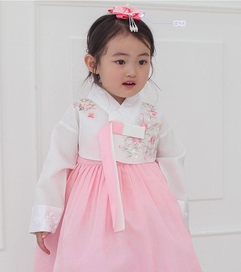 Young girl wearing a girls korean hanbok with white top and red skirt