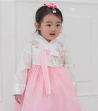 Young girl wearing a girls korean hanbok with white top and red skirt